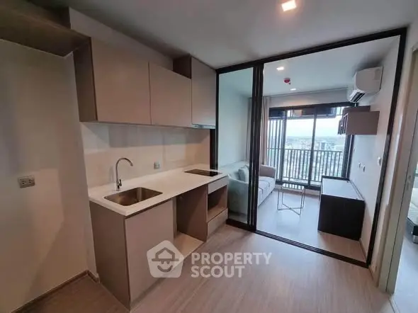 Modern apartment with open kitchen and living room, featuring a balcony with city view.