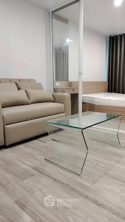 Modern living room with sleek glass coffee table and cozy beige sofa