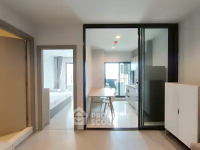 Modern apartment interior with open kitchen and dining area, featuring sleek design and natural light.