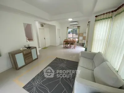 Spacious living room with modern furniture and natural light, ideal for family gatherings.