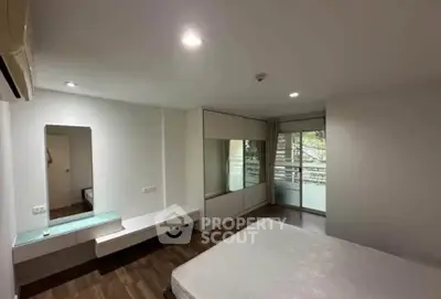 Spacious bedroom with modern design and balcony access in a stylish apartment.