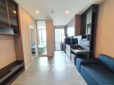 Modern apartment interior with open layout and sleek furnishings, featuring a cozy living area and bedroom view.