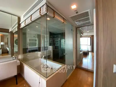 Luxurious modern bathroom with glass-enclosed bathtub and elegant wood flooring