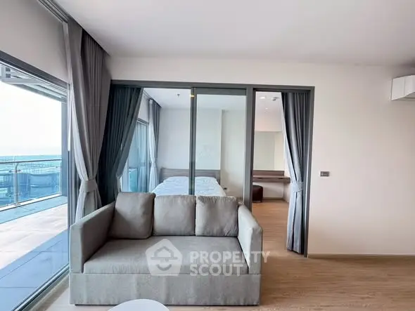 Modern living room with large windows and balcony view in a stylish apartment.