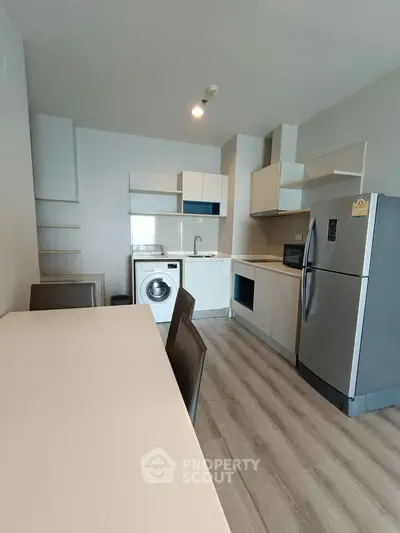 Modern kitchen with sleek appliances and dining area in stylish apartment