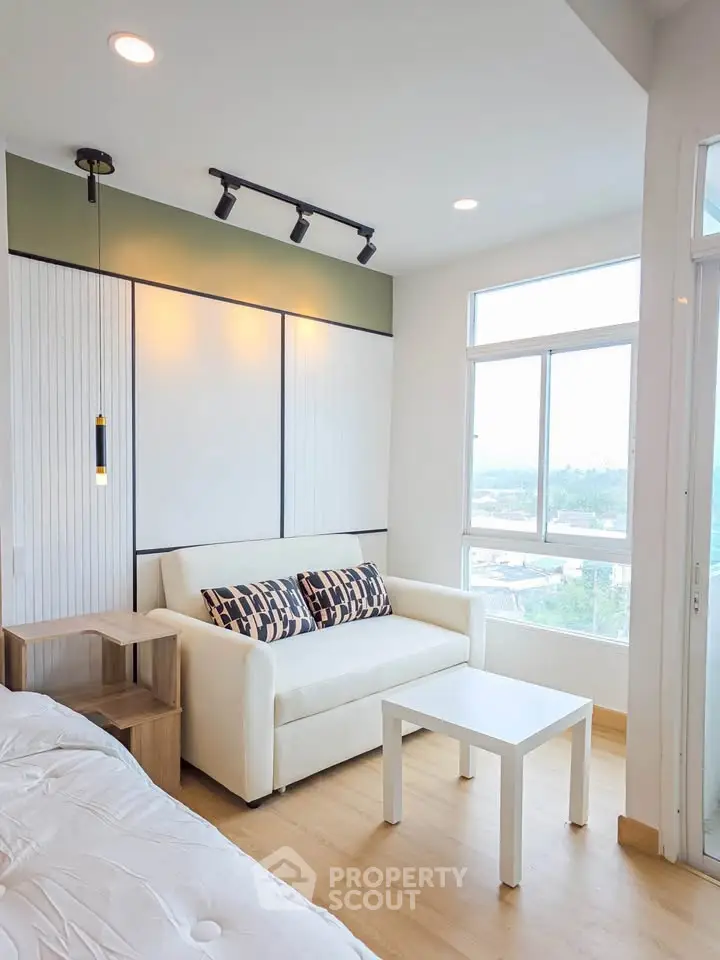 Modern living room with stylish sofa and large windows offering a scenic view, perfect for urban living.