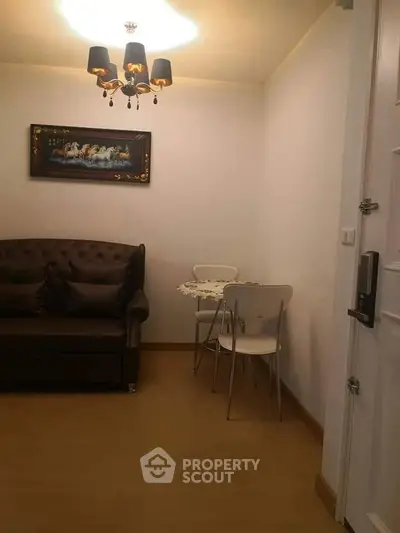 Cozy living room with elegant chandelier and stylish sofa, perfect for intimate gatherings.