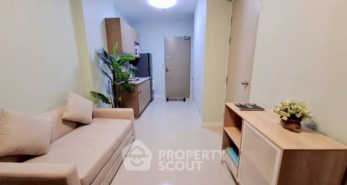 Cozy living room with modern furniture and neutral tones in a compact apartment.