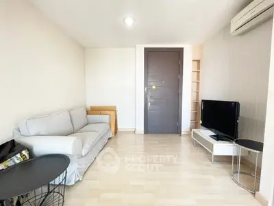 Modern living room with cozy sofa and sleek TV setup in a bright apartment.