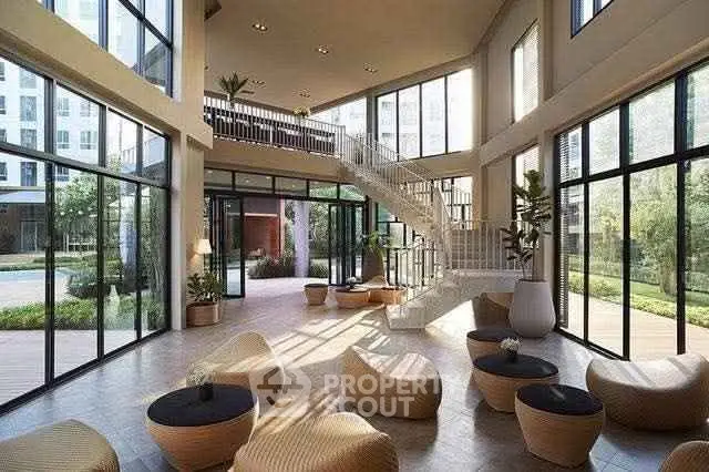 Spacious modern lobby with large windows and stylish seating in a luxury building.