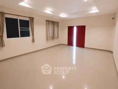 Spacious empty room with polished floors and large windows, ideal for customization.