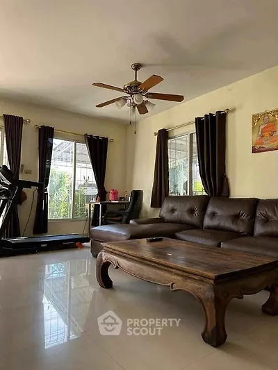 Spacious living room with elegant wooden furniture and natural light, perfect for relaxation.