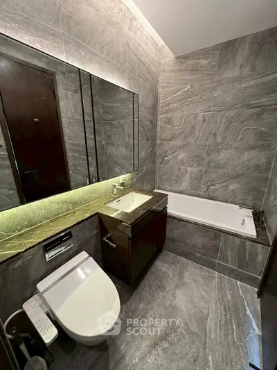 Luxurious modern bathroom with sleek marble tiles and elegant fixtures.