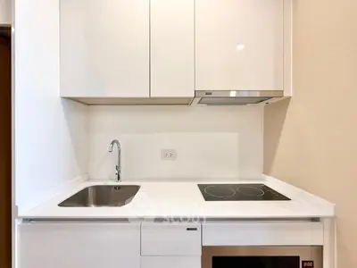 Modern compact kitchen with sleek white cabinetry and built-in appliances