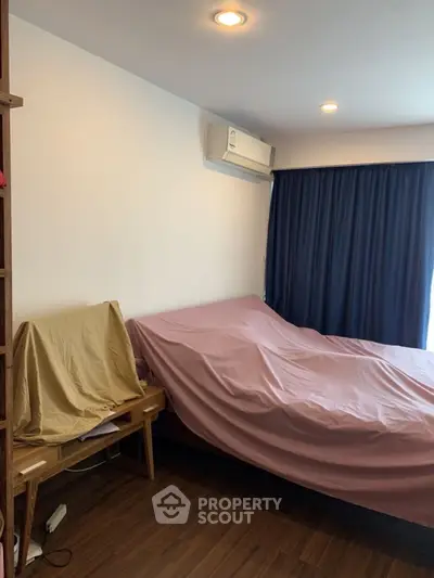 Cozy bedroom with air conditioning and wooden flooring