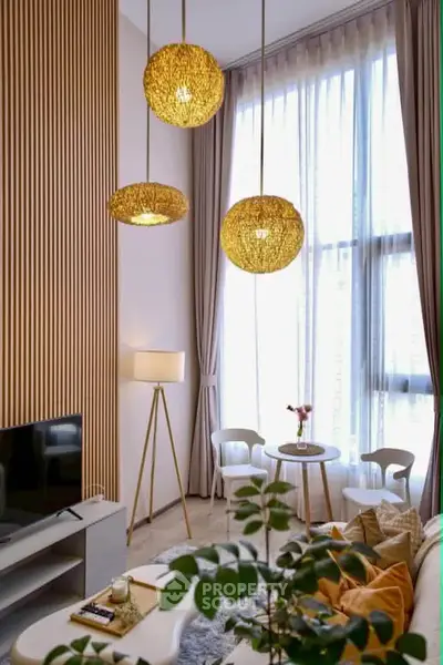 Elegant living room with high ceilings, modern lighting, and floor-to-ceiling windows for natural light.
