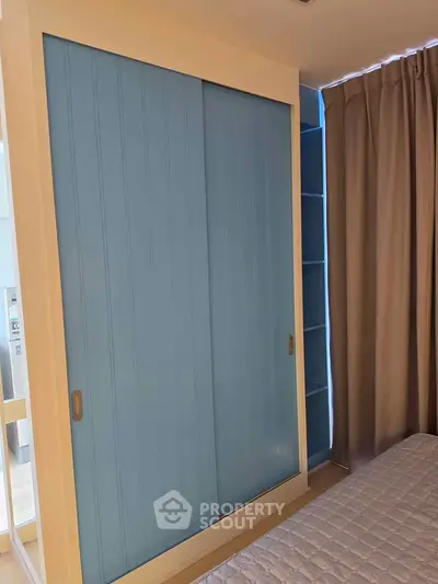 Charming bedroom with blue sliding wardrobe and cozy curtains