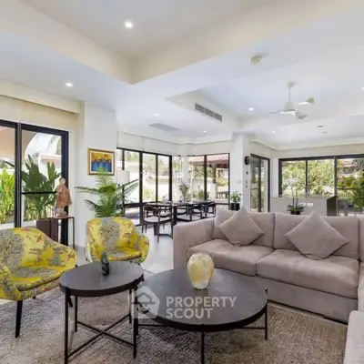 Spacious and elegant living room with modern decor and large windows offering lush garden views.