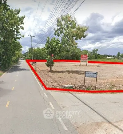 Prime corner plot of land for sale with road access and lush surroundings.