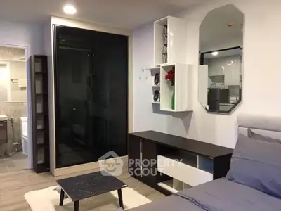 Modern bedroom with stylish decor and sleek furniture, featuring a cozy bed and elegant shelving.