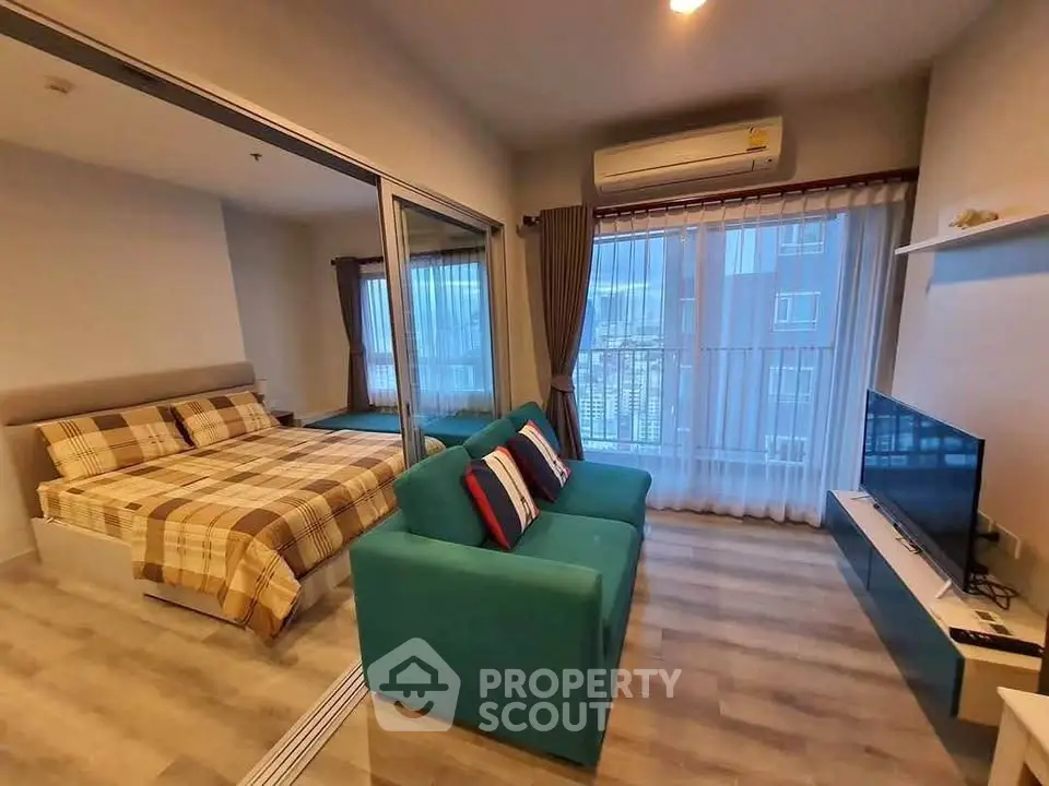 Modern studio apartment with cozy living area and bedroom, featuring large windows and stylish decor.