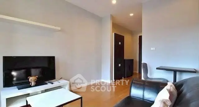 Modern living room with sleek furniture and flat-screen TV, perfect for relaxation.