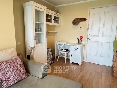 Charming living room with cozy sofa and stylish desk, perfect for relaxation and work.