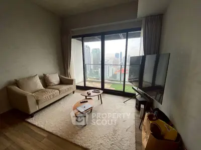 Modern living room with city view, featuring cozy sofa and large TV, perfect for urban living.