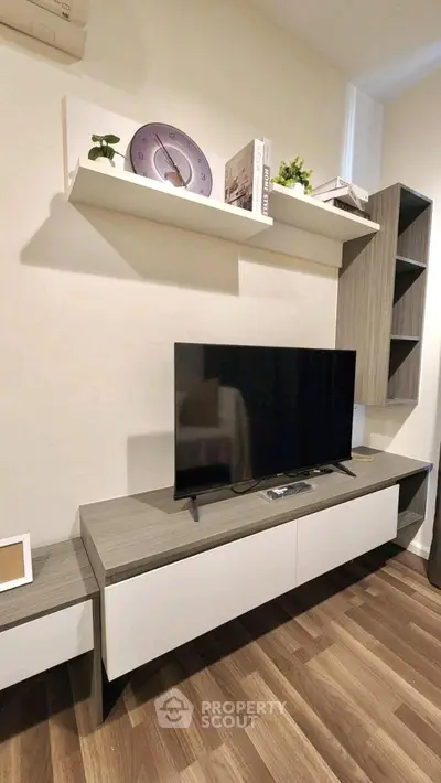 Modern living room with sleek TV stand and wall shelves, perfect for stylish urban living.