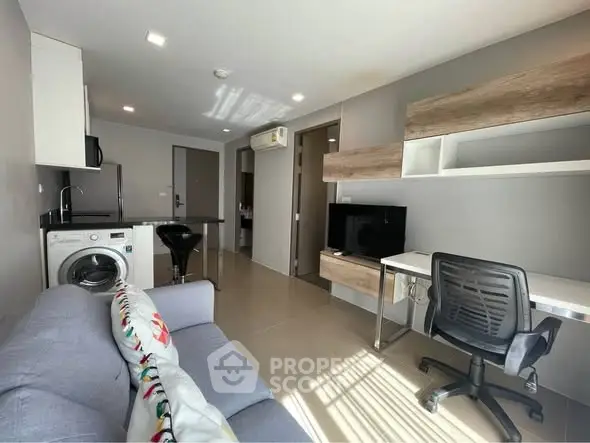 Modern living room with washing machine and study area in a stylish apartment.