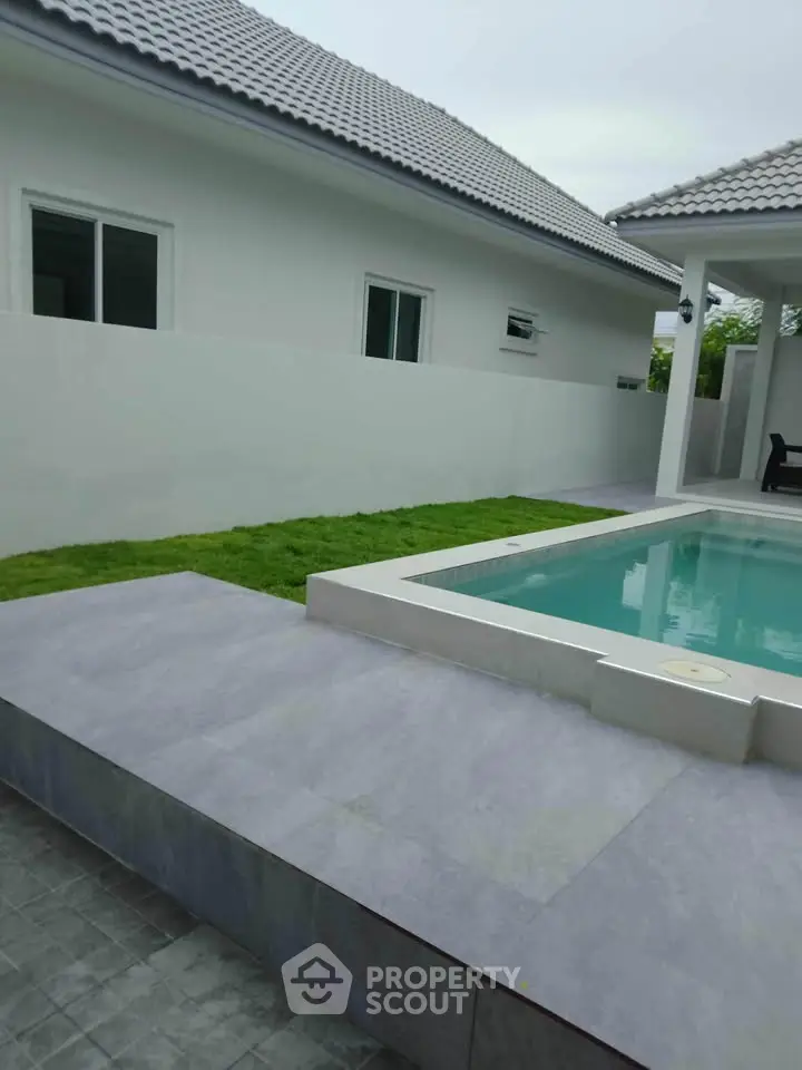 Modern home with sleek pool and lush green lawn, perfect for relaxation and entertaining.
