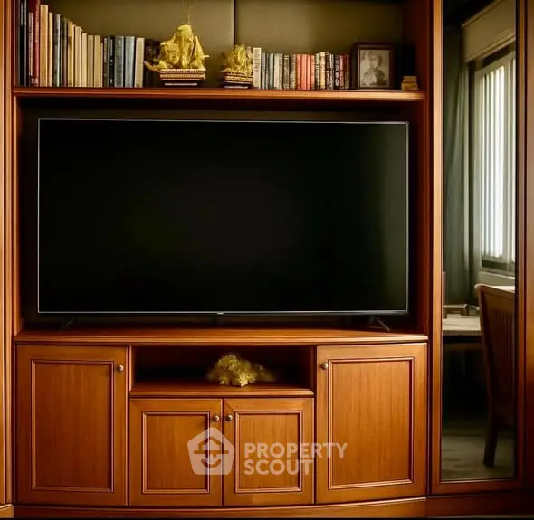 Elegant living room with wooden entertainment center and large TV, perfect for cozy evenings.