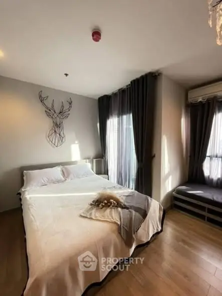 Cozy bedroom with modern decor and natural light, featuring a stylish wall art and elegant curtains.
