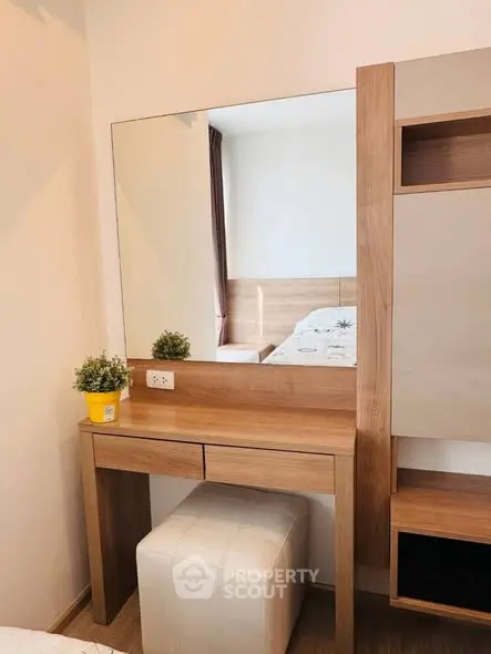 Modern bedroom with stylish wooden vanity and mirror, perfect for a cozy and elegant living space.