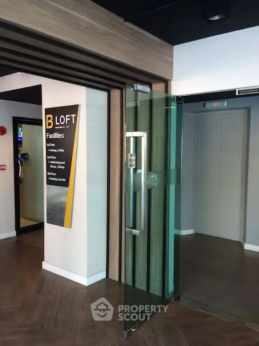 Modern building entrance with glass door and elevator access