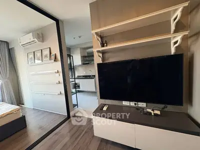 Modern living room with sleek TV unit and open kitchen layout in stylish apartment