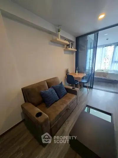 Modern living room with cozy sofa and dining area in open layout apartment.