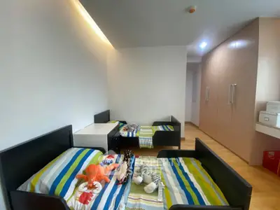 Spacious bedroom with twin beds and ample storage in modern apartment