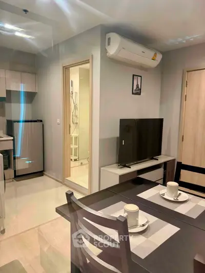 Modern apartment interior with sleek kitchen and cozy dining area, featuring air conditioning and stylish decor.