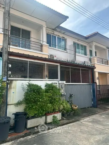 Charming townhouse with modern facade and lush greenery in a serene neighborhood.