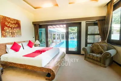 Luxurious bedroom with pool view in a modern villa, featuring elegant decor and spacious layout.
