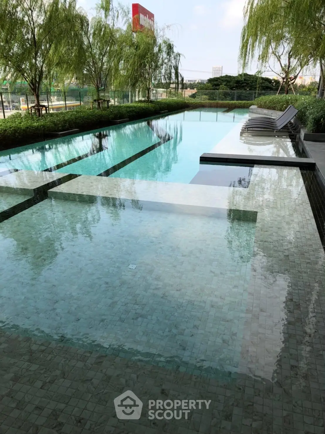 Luxurious outdoor pool area with modern design and lush greenery, perfect for relaxation and leisure.