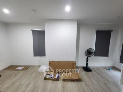 Spacious unfurnished room with wooden flooring and modern blinds, ideal for customization.