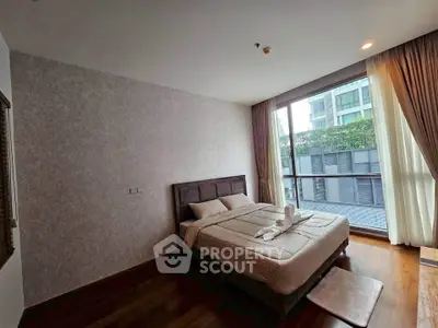 Spacious bedroom with large window offering a view of modern architecture, perfect for urban living.