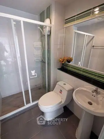 Modern bathroom with glass shower and sleek fixtures in contemporary apartment.