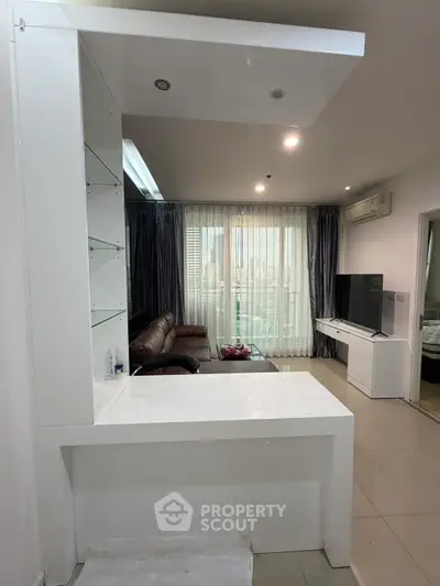 Modern living room with sleek design and city view, featuring leather sofa and large TV unit.