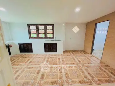 Spacious kitchen with tiled floor and ample natural light, featuring a dual sink and wooden cabinets.