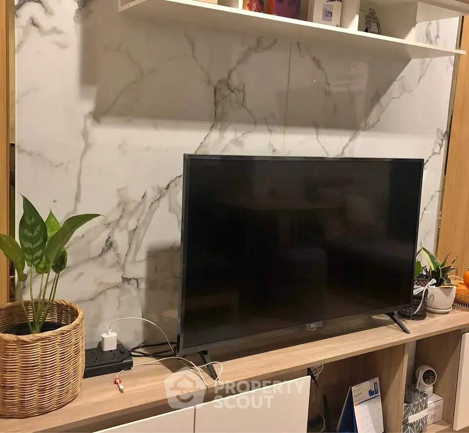 Modern living room with stylish TV setup and marble accent wall