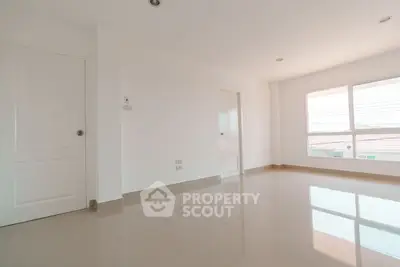 Spacious empty room with large window and glossy tiled floor