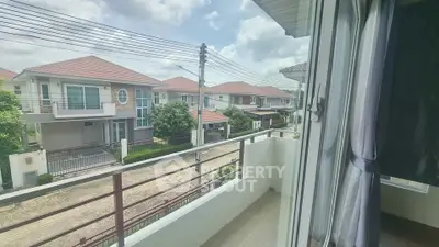 Charming balcony view of suburban houses with red roofs and lush greenery.